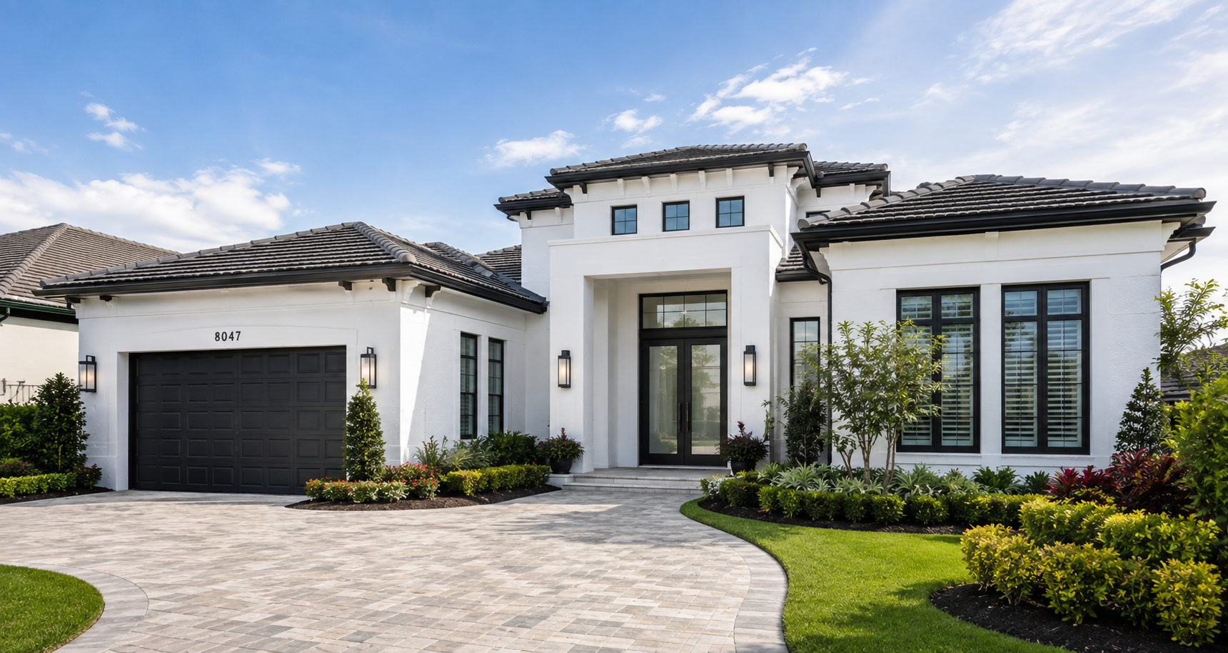 Luxury home with freshly painted white stucco exterior at dusk